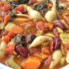 Bowl of tomato base soup with vegetables and pasta